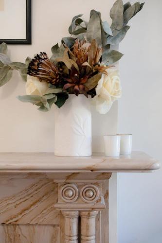 a vase with a bouquet of flowers on a table at Charming On Charles in Launceston