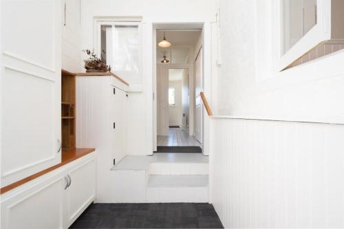 a hallway with white walls and a white staircase at Charming On Charles in Launceston