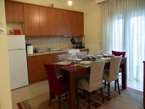 a kitchen with a dining room table with chairs and a refrigerator at The fir trees house - Το σπίτι με τα έλατα in Litochoro