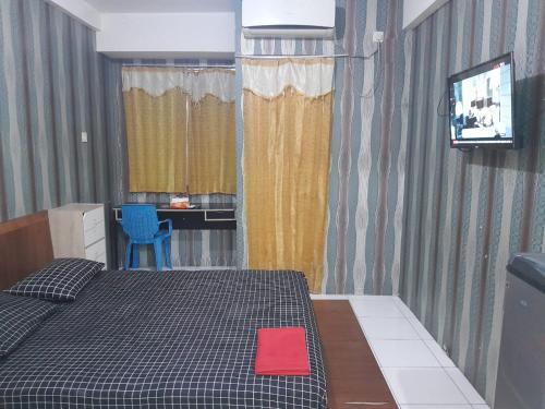 een slaapkamer met een bed met een rood kussen erop bij Apartemen Riverview Sewa Room in Tegalgede