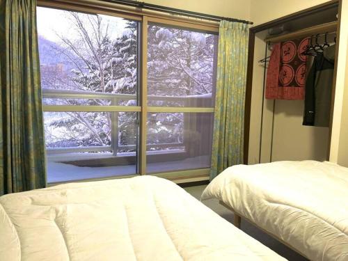 um quarto com vista para uma janela coberta de neve em コンドミニアム定山渓307 em Jozankei