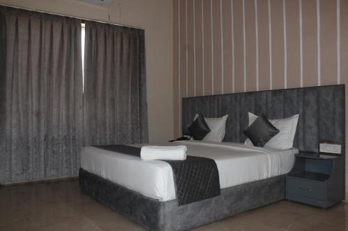 a bedroom with a large bed and a window at The Desi Rootz Hotel And Restaurant in Rāmnagar