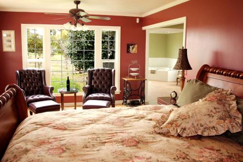 een slaapkamer met een bed en 2 stoelen en een raam bij Sequoia View Vineyard in Sanger