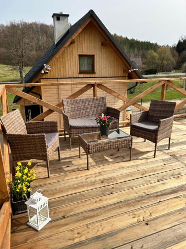 a wooden deck with chairs and a house at Siedlisko Złota Góra domki całoroczne na Kaszubach in Brodnica