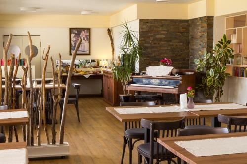 a restaurant with tables and a piano in the background at GRÜNER HEINRICH - Bett&Frühstück in Oberaichwald