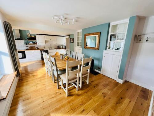 a kitchen and dining room with a table and chairs at Bi-Folds/Sonos/Large Open Plan/Central/Parking in Cheddar