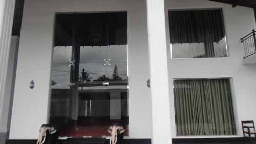 a white house with a window with a table and chairs at The Kingston Hotel in Kiribathgoda