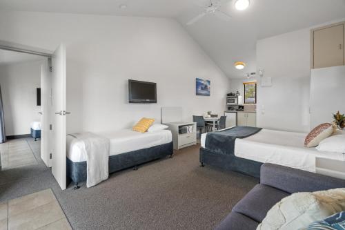 a hotel room with two beds and a couch at Tasman Holiday Parks - Miranda in Miranda