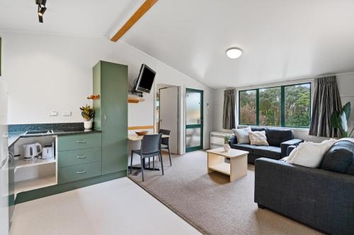a living room with a couch and a kitchen at Tasman Holiday Parks - Miranda in Miranda