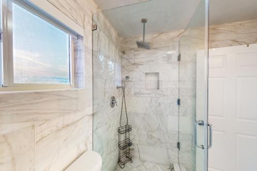 a bathroom with a shower with a toilet and a window at Hammock Haven in Key Largo