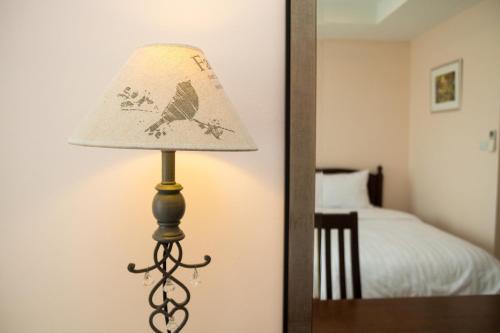 a lamp sitting on a table next to a bedroom at Takanta Place in Udon Thani