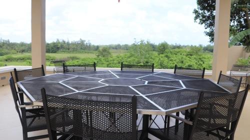 a black table and chairs on a porch with a view at Dunest Villa in Bentota