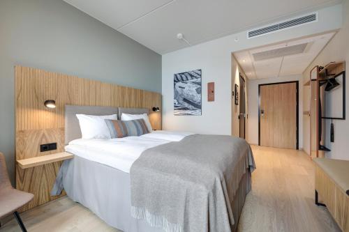 a bedroom with a large bed and a desk at Quality Hotel Harstad in Harstad