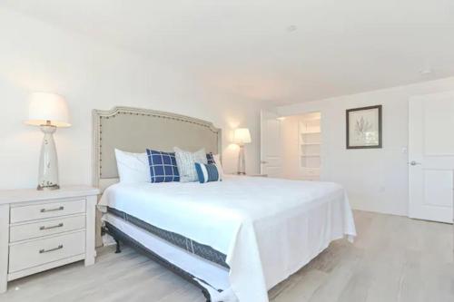 a white bedroom with a large white bed and a lamp at Harbourtown Suites, Unit 211 in Plymouth