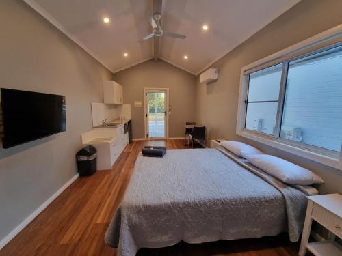 a bedroom with a bed and a flat screen tv at Gulgong Tourist Park in Gulgong