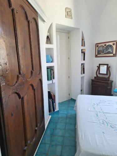 a bedroom with a bed and a book shelf at L'Osservatorio - Luxury Guest House in Capri