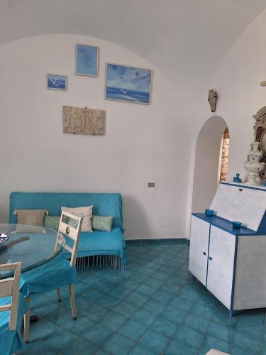 a living room with a blue couch and a table at L'Osservatorio - Luxury Guest House in Capri