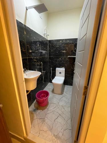 a bathroom with a toilet and a sink at KM MANSION in Chennai