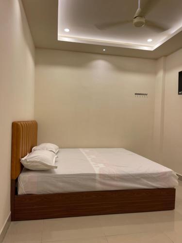 a bed with white sheets and pillows in a room at KM MANSION in Chennai