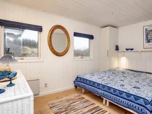 1 dormitorio con cama y espejo en la pared en Holiday home Blokhus LXX en Blokhus