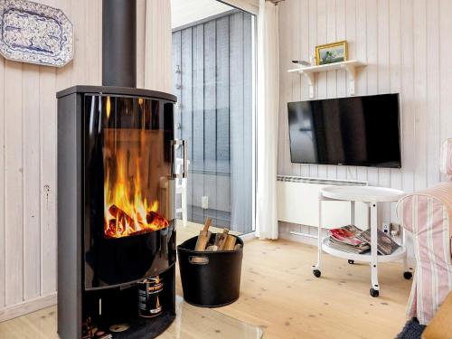 a fireplace in a living room with a tv at 4 star holiday home in Blokhus-By Traum in Blokhus