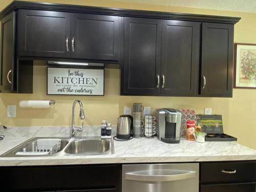 a kitchen with black cabinets and a sink at Sundance' Acres *Brand New House*with hot tub in Spring Hill