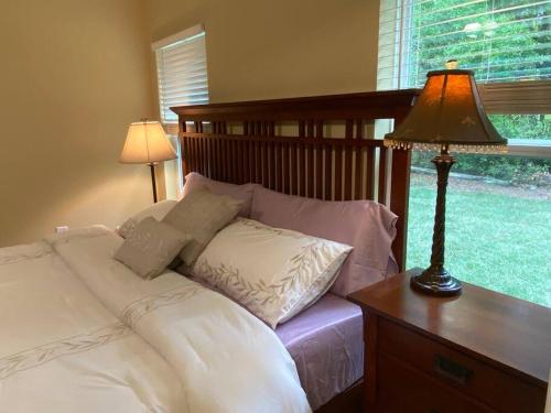 a bedroom with a bed and a table with a lamp at Sundance' Acres *Brand New House*with hot tub in Spring Hill