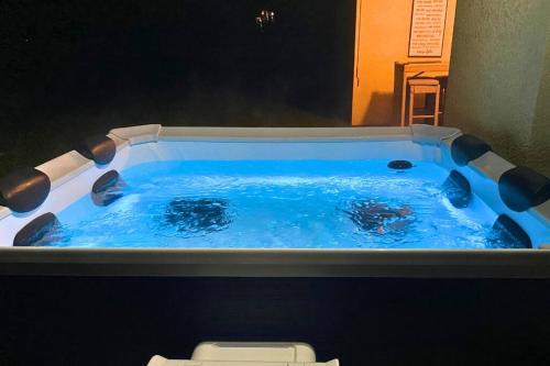 a hot tub with blue water in a bathroom at Sundance' Acres *Brand New House*with hot tub in Spring Hill