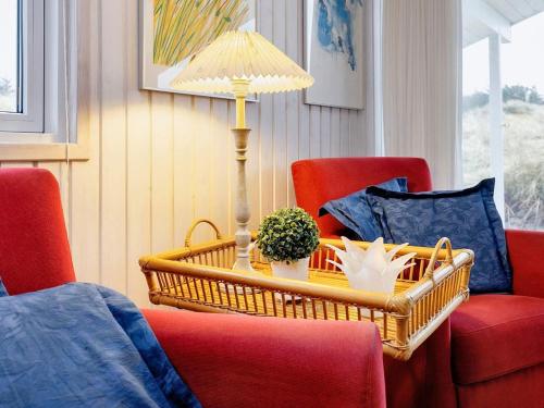 a room with a table with a lamp and chairs at 4 star holiday home in Blokhus-By Traum in Blokhus