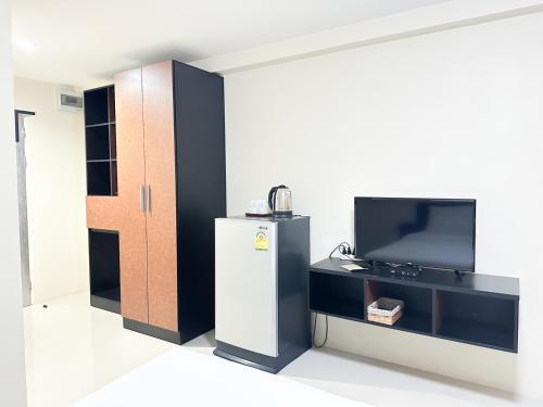 een kamer met een koelkast en een televisie bij Tone Condorent Hotel in Chachoengsao
