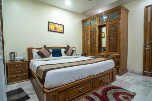 una camera con un grande letto e mobili in legno di Hotel NK North Star " Foreign Guest Not Allowed " a Nuova Delhi