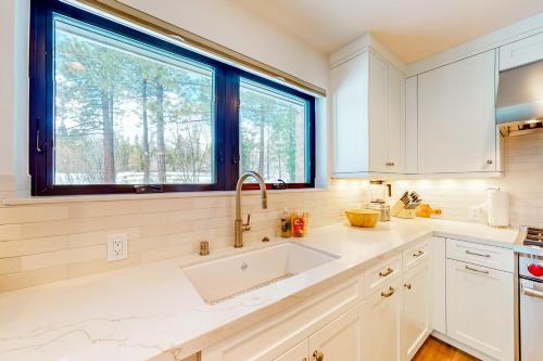 Una cocina blanca con fregadero y ventana. en Piney Way, en Incline Village