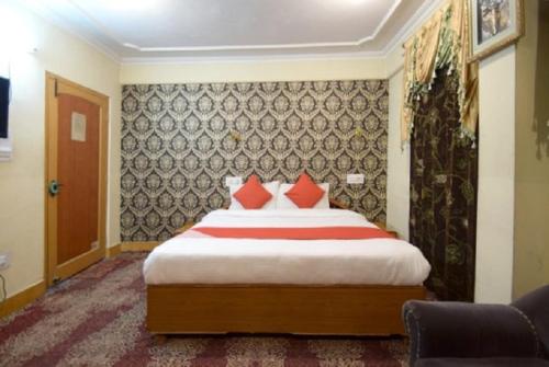 a bedroom with a large bed with red pillows at hotel city plaza in Srinagar