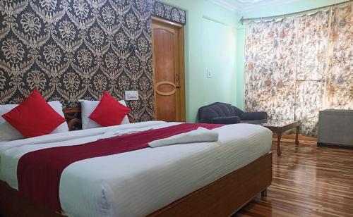 a bedroom with a large bed with red pillows at hotel city plaza in Srinagar