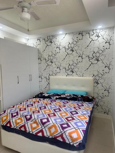 a bedroom with a bed with a patterned wall at confort residance in Antalya