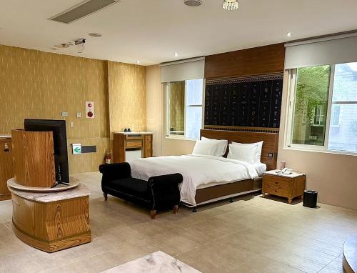 a bedroom with a bed and a chair and a television at All-Ur Boutique Motel-Jhu Shan Branch in Zhushan