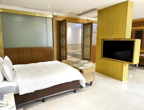 a bedroom with a bed and a flat screen tv at All-Ur Boutique Motel-Jhu Shan Branch in Zhushan