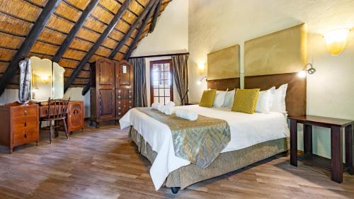 a bedroom with a bed and a dresser in a room at Woodlands Guest House in Hazyview
