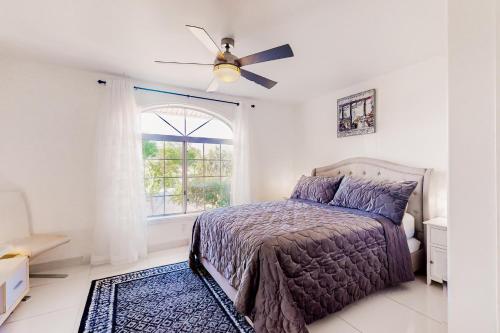 パームデザートにあるPalm Desert Doveのベッドと天井扇風機のある寝室