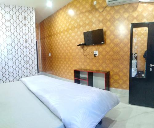 a bedroom with a bed and a tv on a wall at Hotel Royal Grand in Dehradun