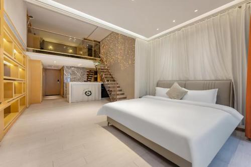 Un dormitorio con una gran cama blanca y una escalera en Yidu-Doya Apartment, en Guangzhou