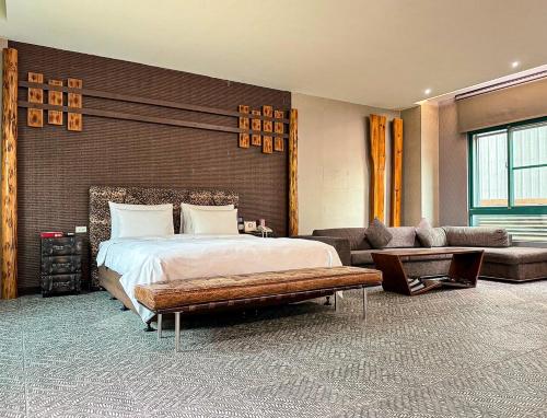 嘉義市的住宿－歐遊國際連鎖精品旅館 - 嘉義館，一间卧室配有一张大床和一张沙发