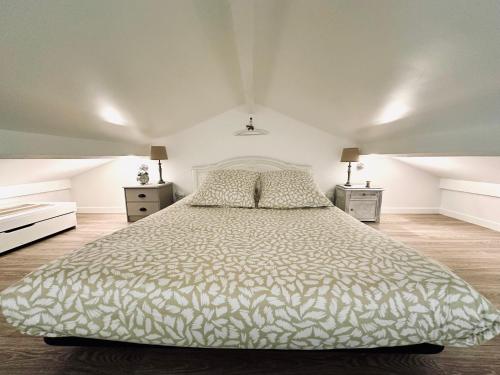een slaapkamer met een groot bed en 2 nachtkastjes bij SLOW LIFE Cottage, paradise near Bordeaux in Camarsac
