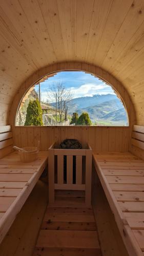 an empty sauna with a bench and a window at Hofer Hof in Feldthurns