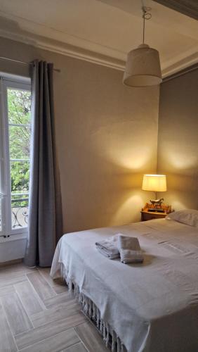 een slaapkamer met een bed met een lamp en een raam bij bastide St Joseph in Eyguières