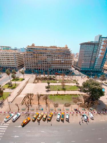 a parking lot with cars parked in front of a large building at Ideal F3 in Dakar