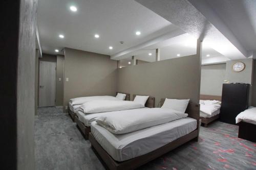 a room with a row of beds in it at TOKYOGUEST日本橋 in Tokyo