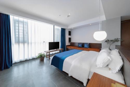 a bedroom with a large bed and a television at Phoenix Best River View B&B in Fenghuang