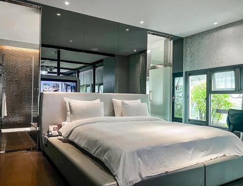 新荘区にあるオール ユア ブティック モーテル シンジュァン　ブランチの大きなベッドルーム(白いシーツ付きの大きなベッド付)