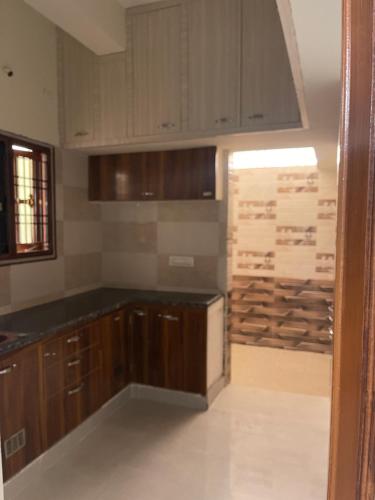 a kitchen with wooden cabinets and a stack of logs at Sun Home Stays in Tirupati